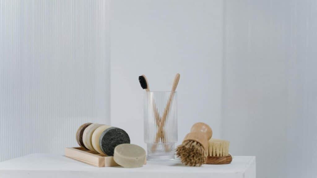 A minimalist arrangement of eco-friendly bathroom essentials including wooden brushes and natural soap bars.