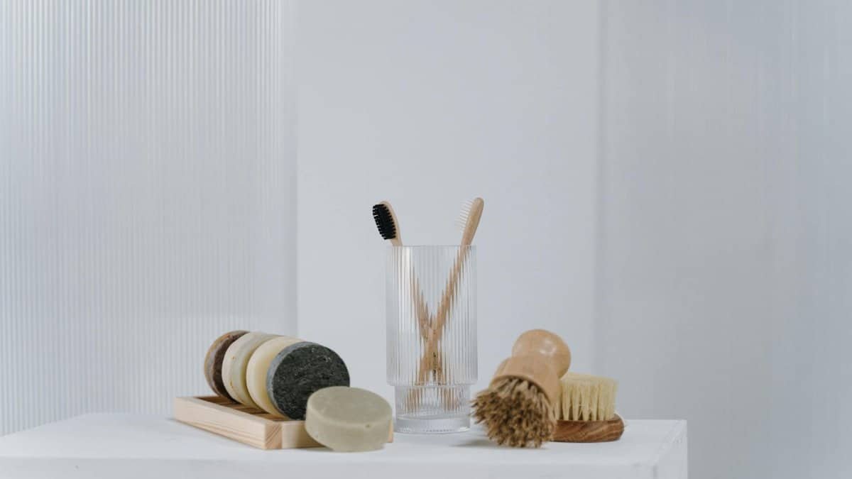 A minimalist arrangement of eco-friendly bathroom essentials including wooden brushes and natural soap bars.