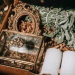 A beautifully arranged gift box containing sage, candles, and decorative items.