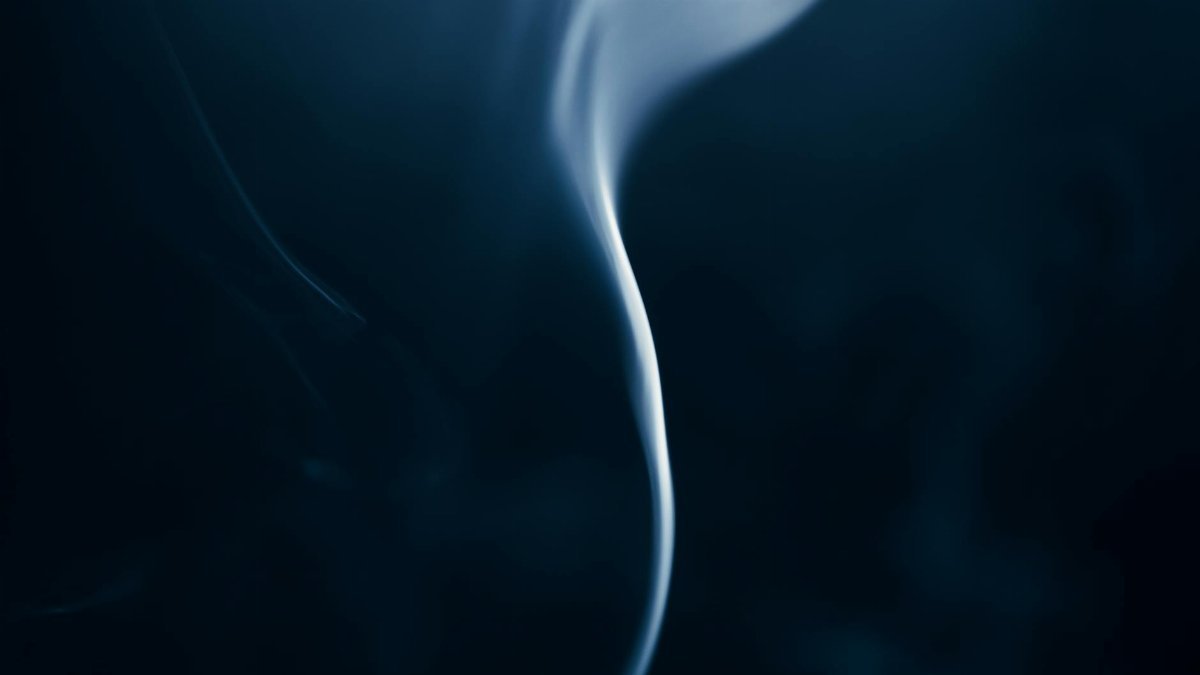 Artistic abstract photo of swirling smoke against a dark backdrop.