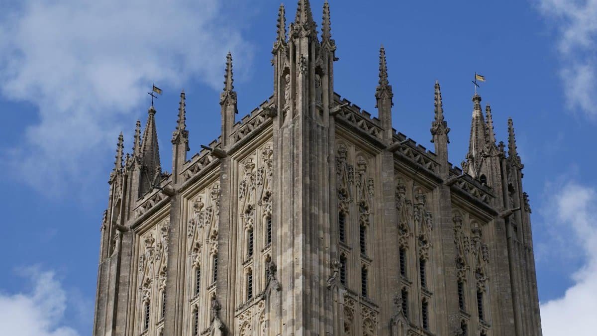 Detailed view of Wells Cathedral's gothic architecture against a clear blue sky in England.