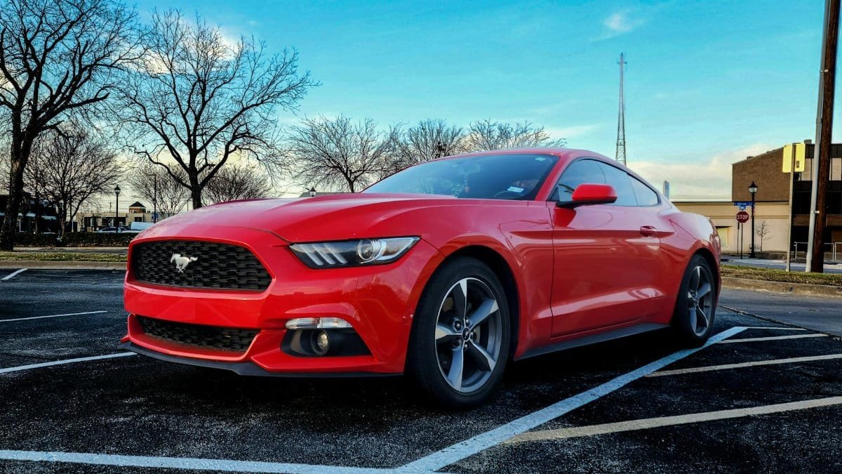 Vibrant red Ford Mustang GT parked on a clear day in Arlington, Texas.
