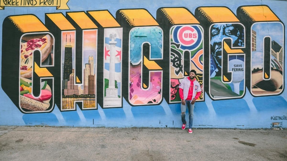 Colorful street art mural in Chicago featuring iconic city symbols and a person posing.