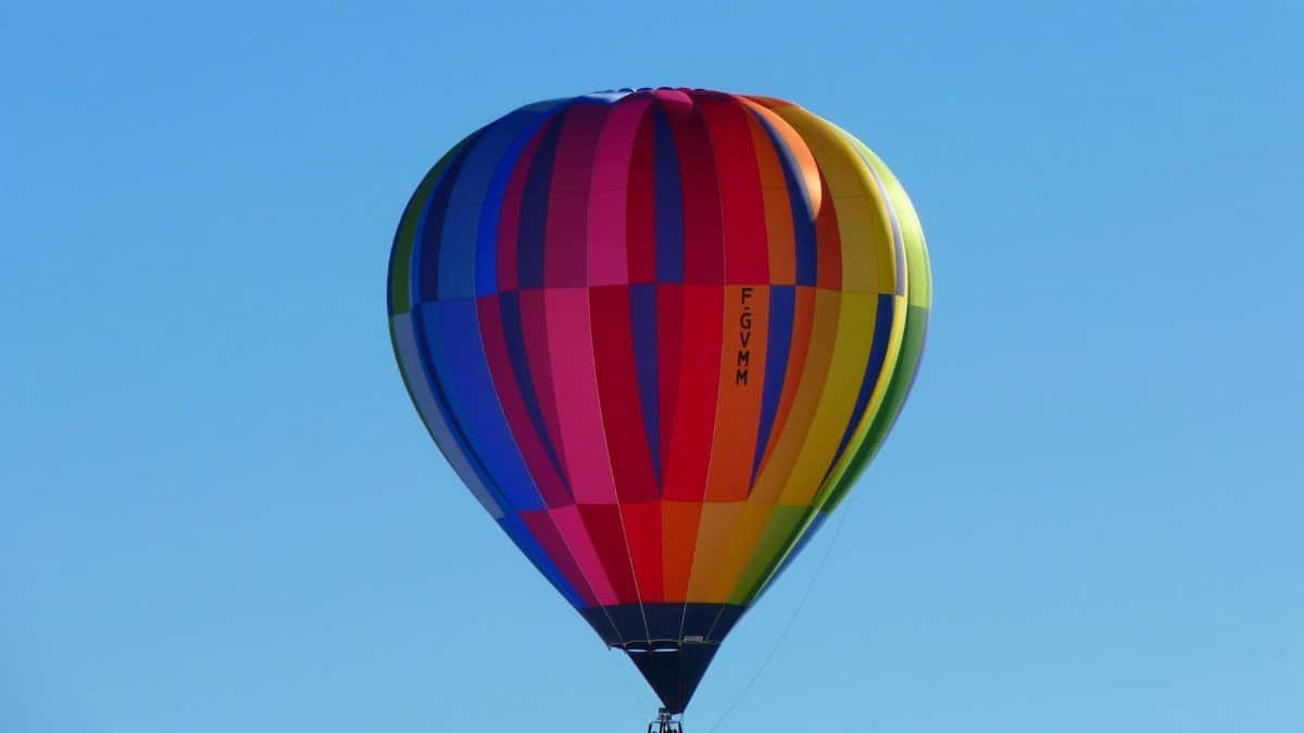 Colorful hot air balloon soaring high in a clear blue sky, capturing a sense of adventure and freedom.
