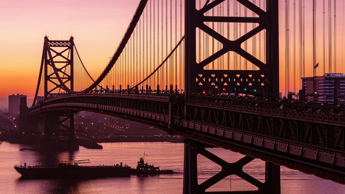 Stunning sunset view of the Ben Franklin Bridge spanning the Delaware River in Philadelphia.