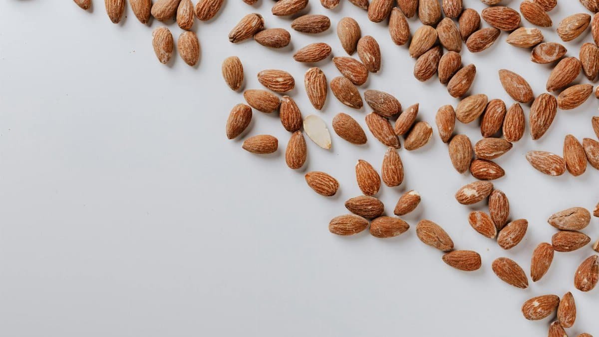 Top view of delicious and nutrition almond cluttered on white table illustrating healthy food eating concept