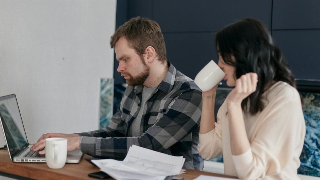 A couple at home, focusing on budgeting and finances with a laptop.