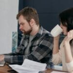 A couple at home, focusing on budgeting and finances with a laptop.