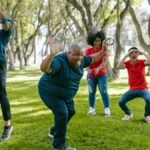 Diverse group enjoying team building games outdoors with joyful expressions.