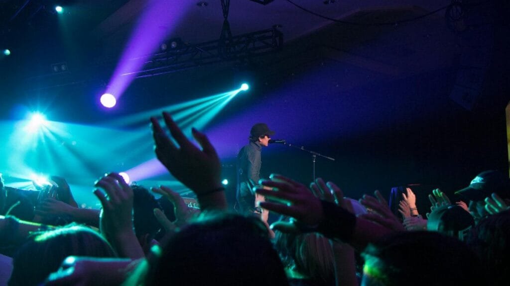 An exciting live concert performance with vibrant lights and enthusiastic crowd.