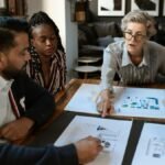 A diverse group of professionals brainstorming over charts in a stylish office setting.