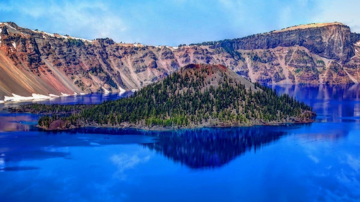 Stunning view of Crater Lake with Wizard Island in Oregon, showcasing the vibrant blue waters and rugged landscape.