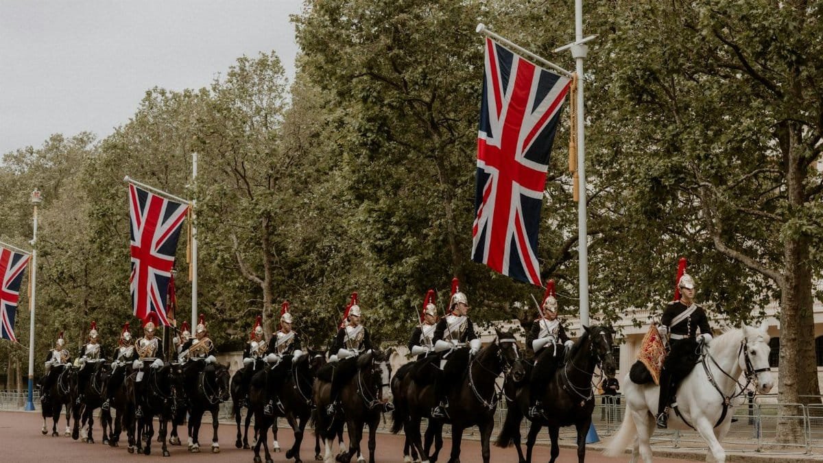 Ceremonial cavalry with Union Flags in a historical parade on The Mall, London.