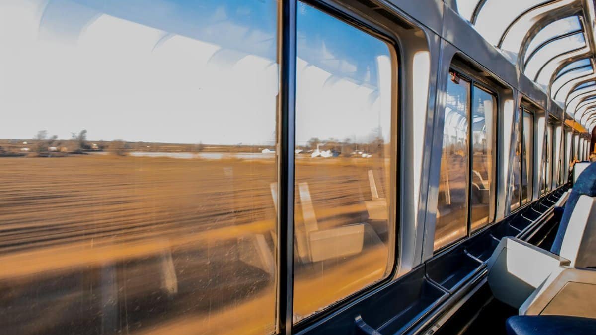 Interior of a modern train traveling at high speed with a scenic landscape view through large windows