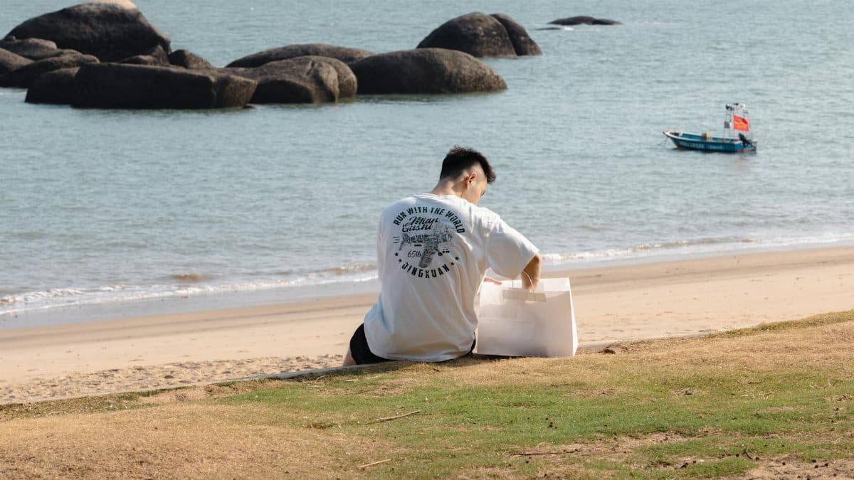Man enjoying a peaceful day by the seaside in Xiamen, China with eco-friendly packaging.