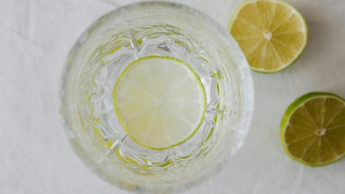 Top view of a refreshing lime-infused water with citrus slices in a crystal glass.
