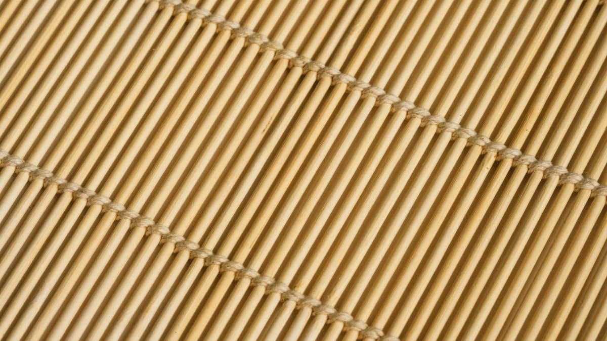 Detailed close-up of a natural bamboo mat surface with parallel wooden sticks.