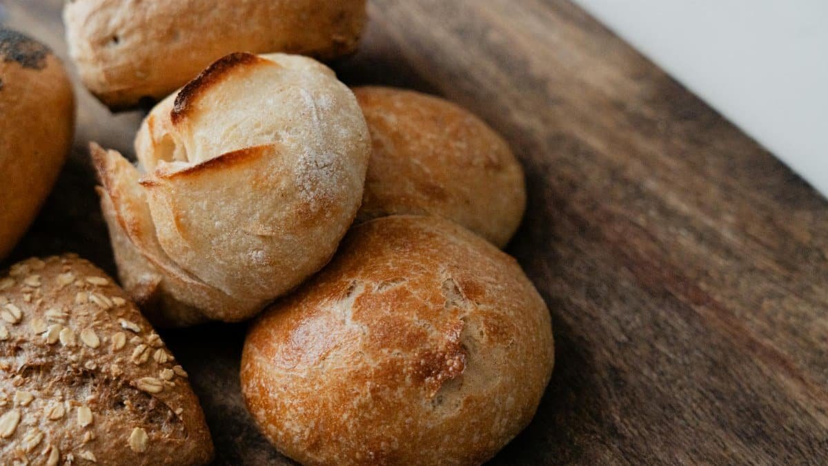 Rustic artisan bread rolls in various styles on a wooden surface.