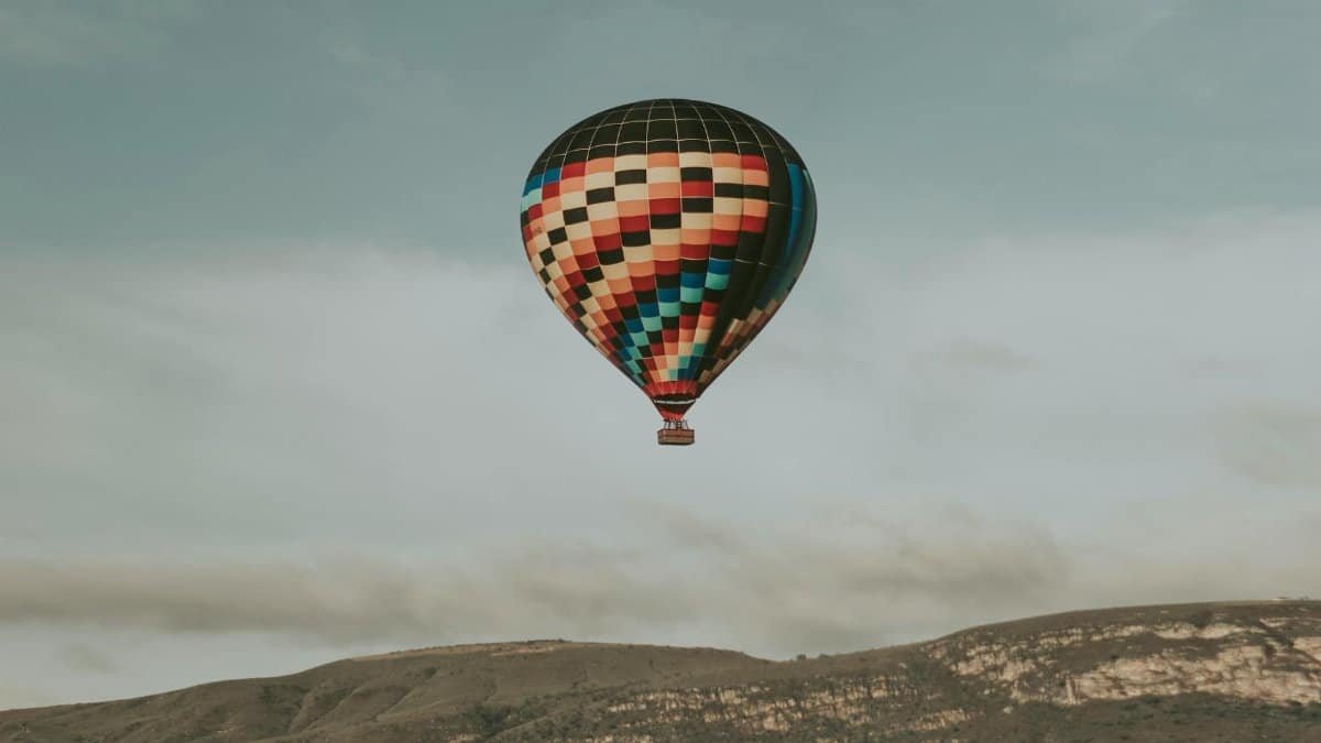 A vibrant hot air balloon floats over Capitólio, MG, Brazil, showcasing breathtaking views.