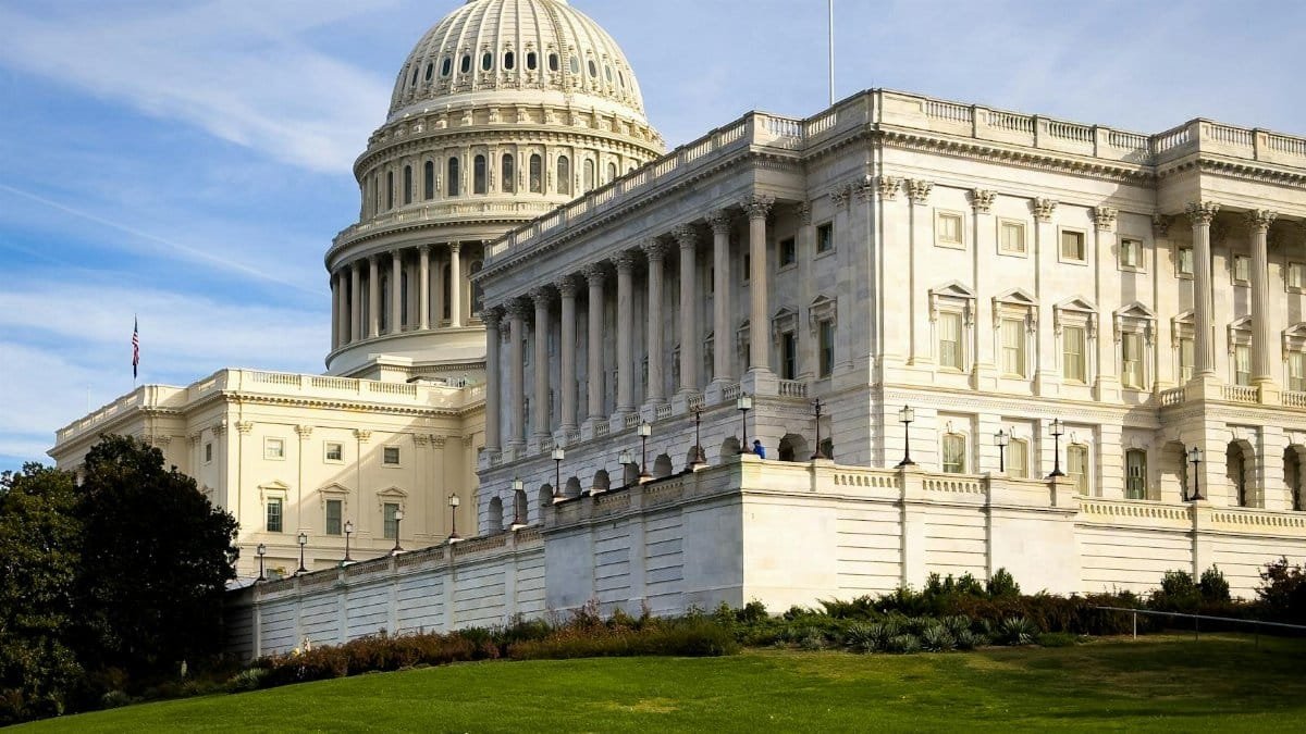 A picturesque view of the US Capitol Building in Washington, DC, under a clear sky.