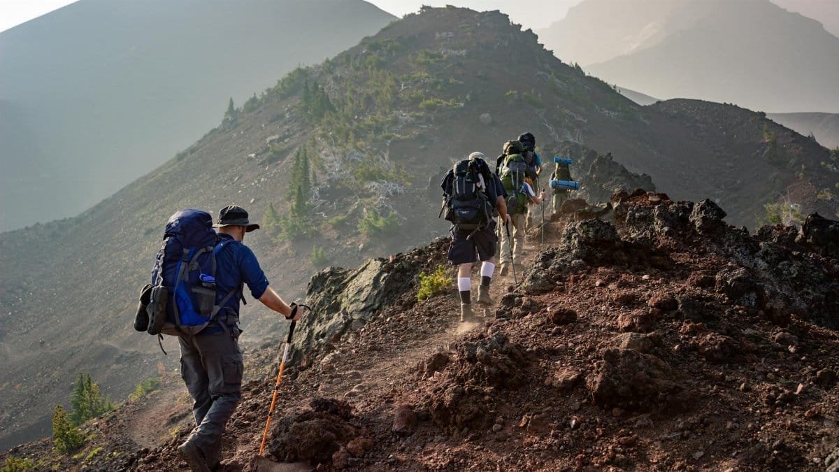 Group of hikers trekking on a rugged mountain trail in Oregon's scenic outdoors.