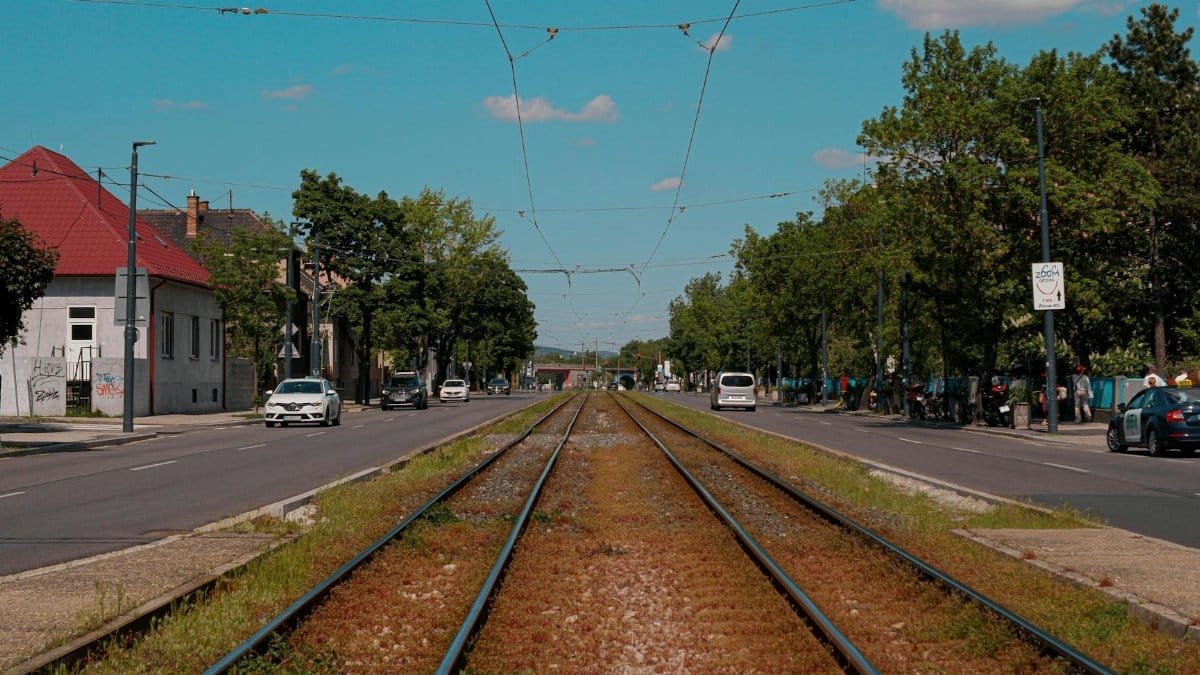 Urban railway tracks in Bratislava on a bright summer day with clear blue skies.