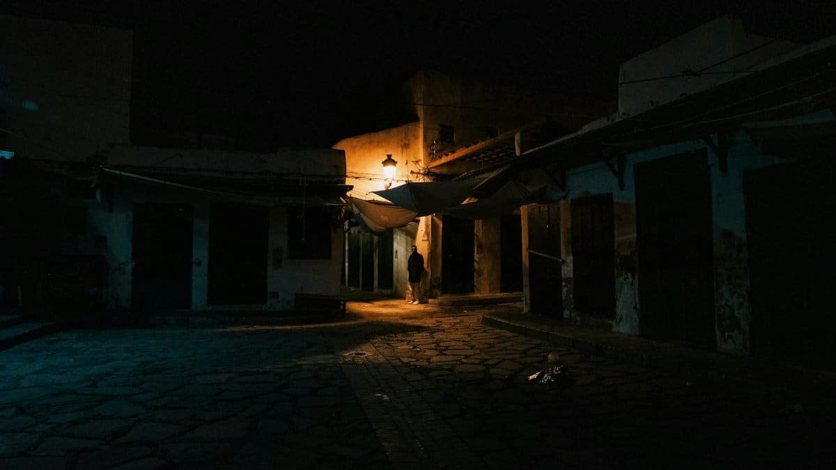 Eerie nighttime alley scene in Tangier's old town, showcasing architecture and dim lighting.