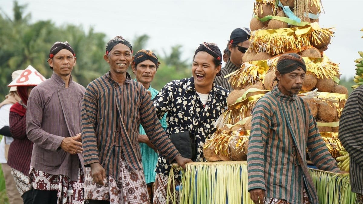 Men in traditional costumes celebrating a harvest festival with colorful decorations.