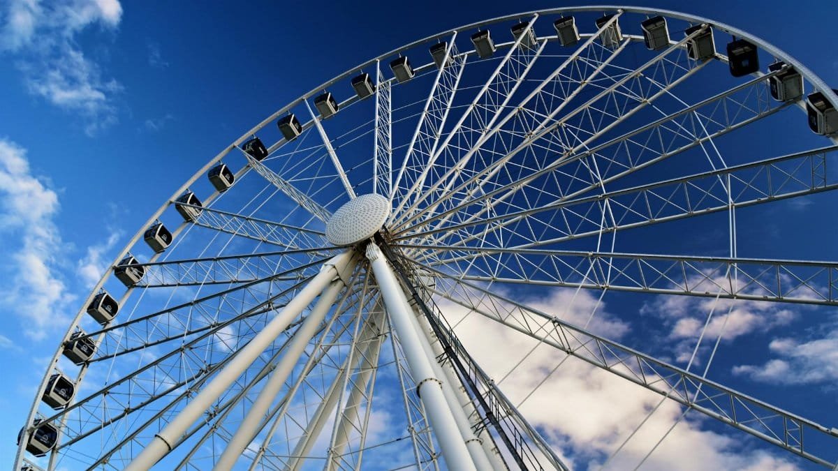 View of the Seattle Great Wheel with a vibrant blue sky and scattered clouds.