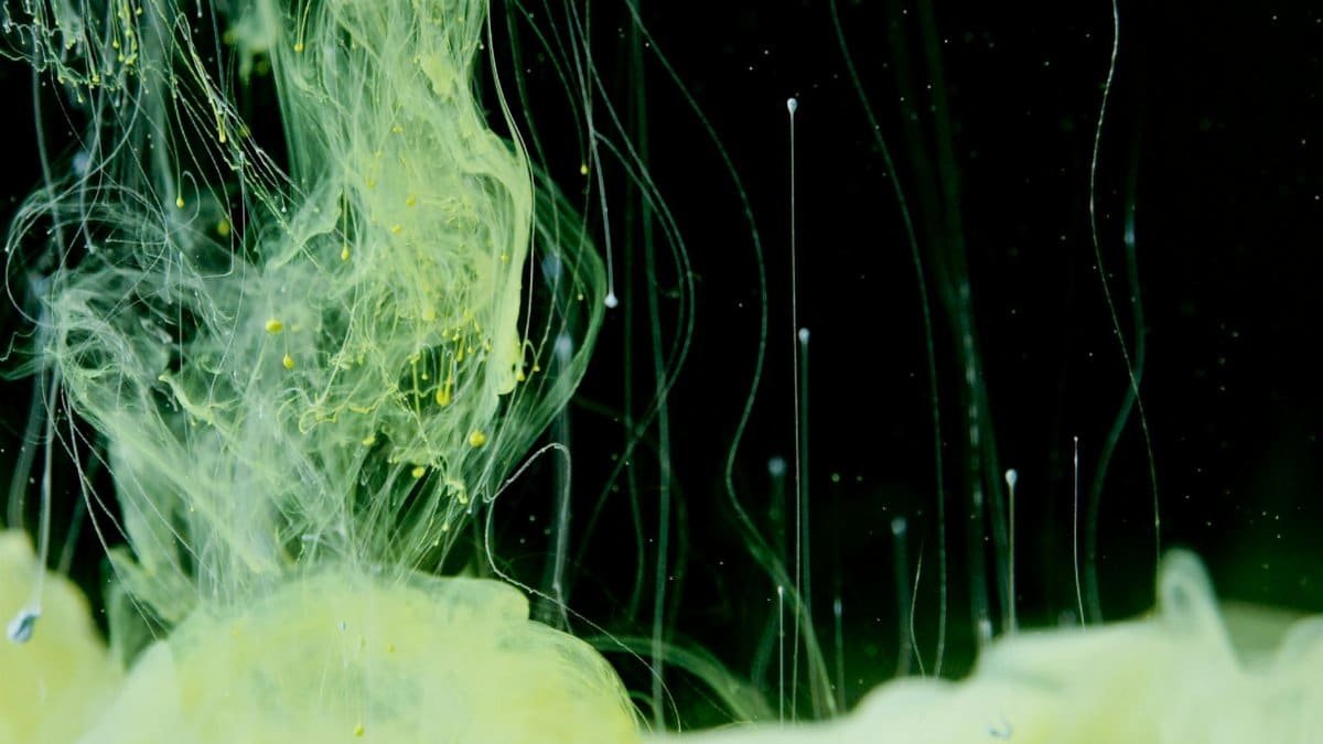 A mesmerizing close-up of yellow ink flowing in liquid creating an abstract art form.