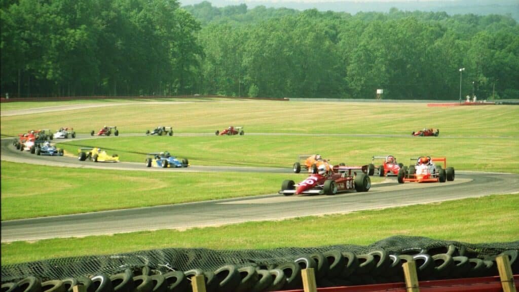 A thrilling outdoor car race featuring colorful formula cars speeding around a track.