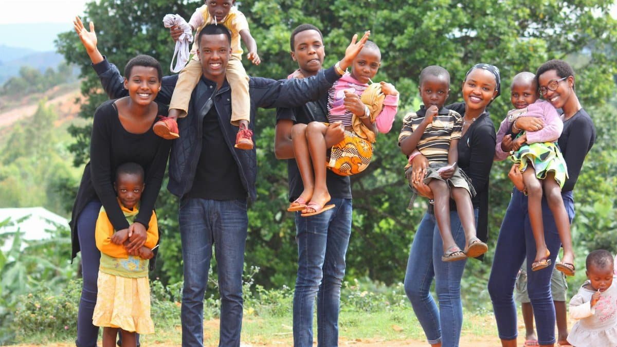 A vibrant and joyful group of family members celebrating together outdoors in Gitega, Burundi.