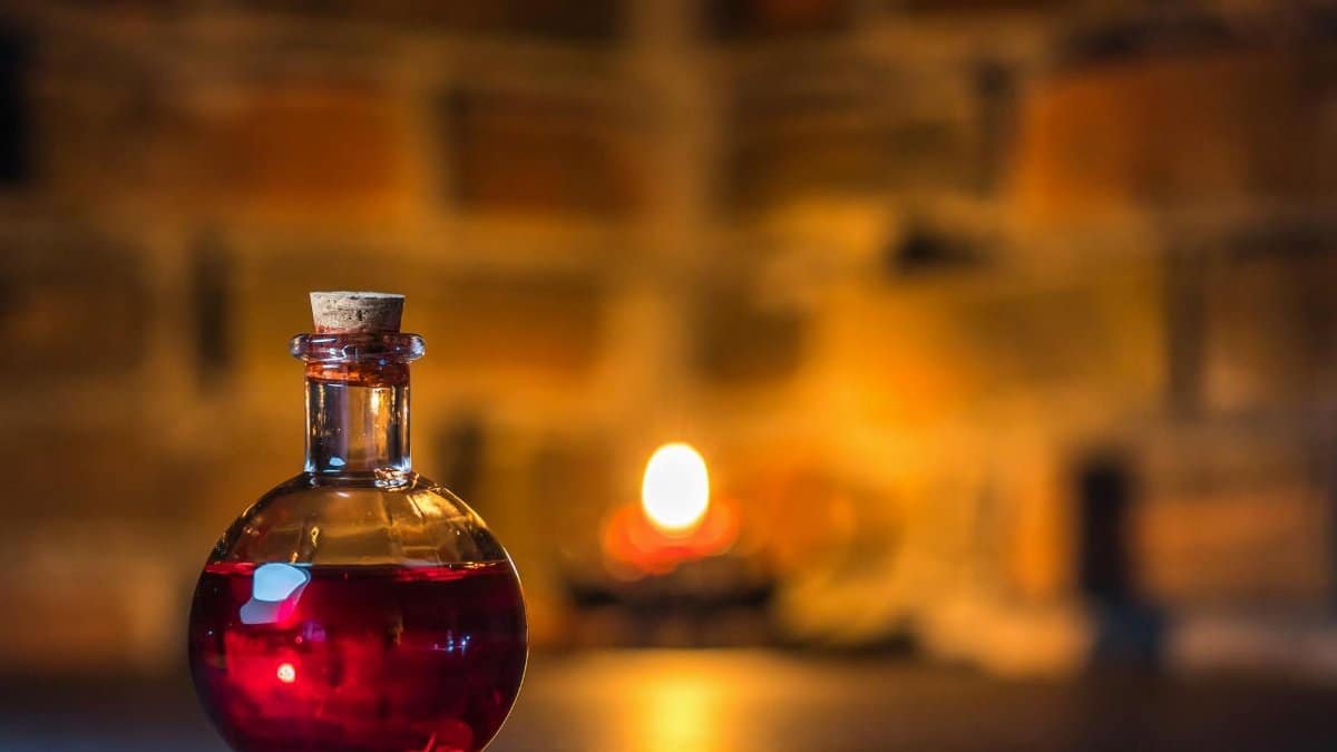 A mystical potion bottle glows warmly in candlelight against a rustic brick background.