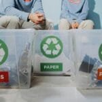 Volunteers organize recyclables into glass, paper, and plastic bins to promote eco-friendly practices.