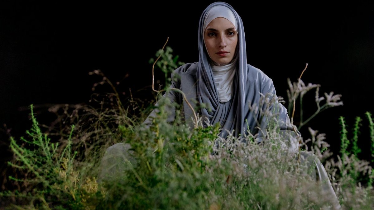 Studio portrait of a woman in hijab with a natural setting background.