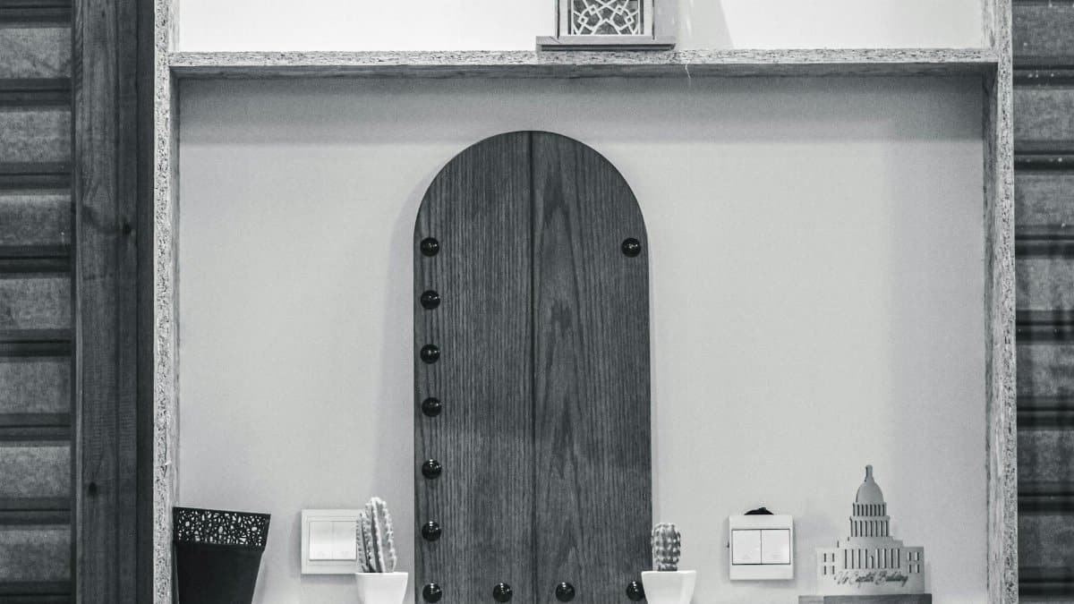 Minimalist wooden shelf with small cacti and decor pieces, emphasizing simplicity and style.