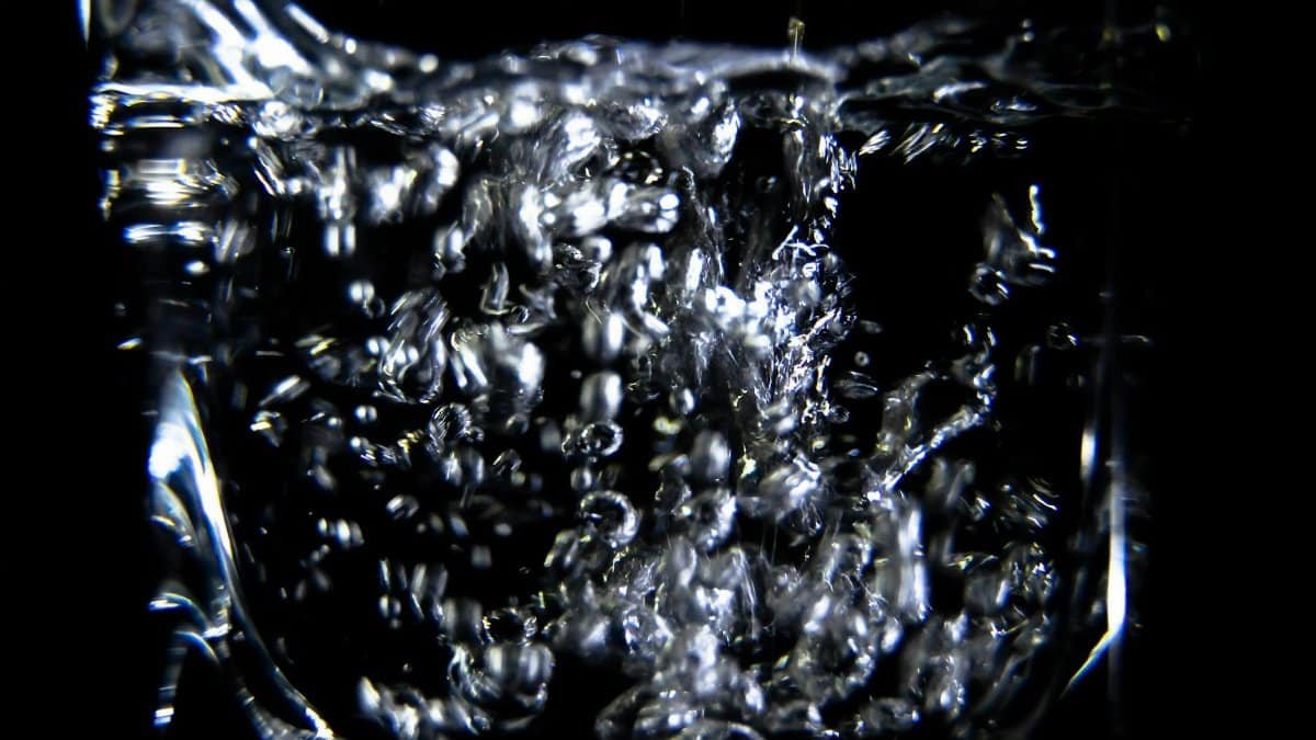 Close-up of water splashing with air bubbles in a clean and clear setting.