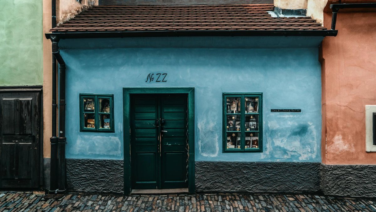 Colorful facade on Golden Lane in Prague, showcasing historical architecture and cobblestone path.
