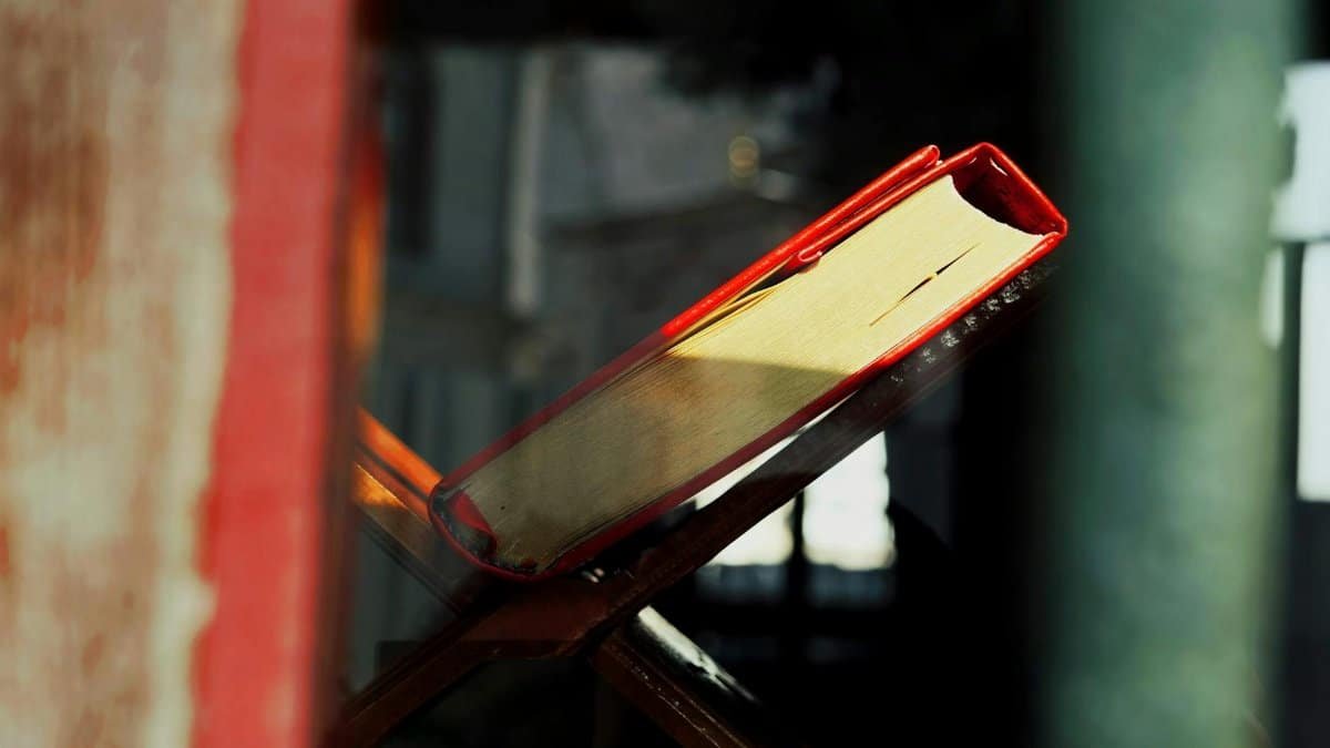 A red book resting on a stand by a window in Istanbul, Türkiye, captured in warm daylight.