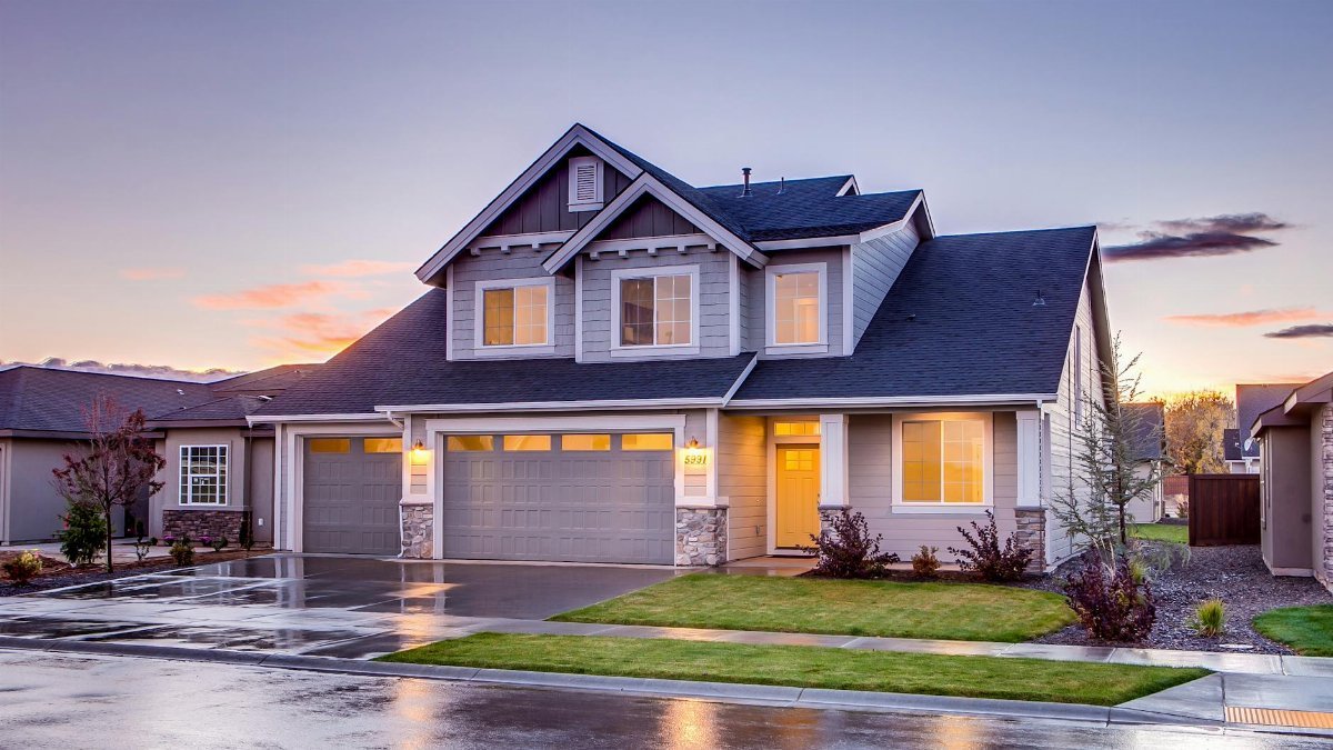 Elegant suburban home with driveway at sunset showcasing modern architecture.