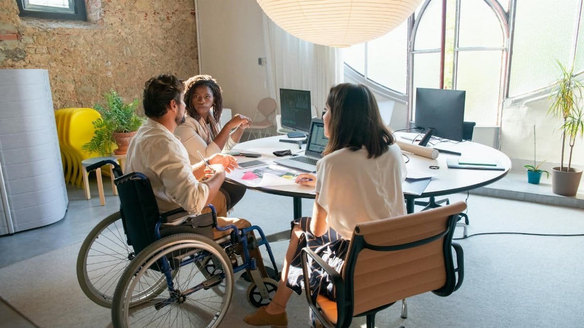 A diverse group of coworkers collaborating in an accessible office environment with a focus on inclusivity.