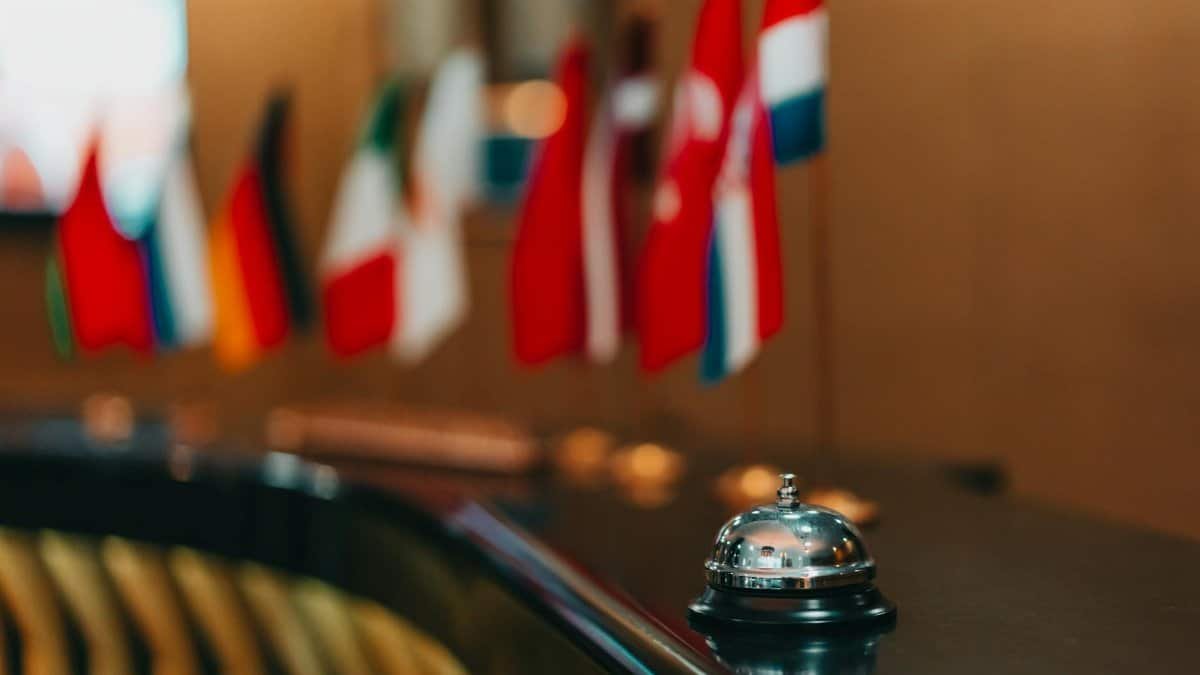 Sophisticated hotel lobby with a reception bell and array of international flags in focus.