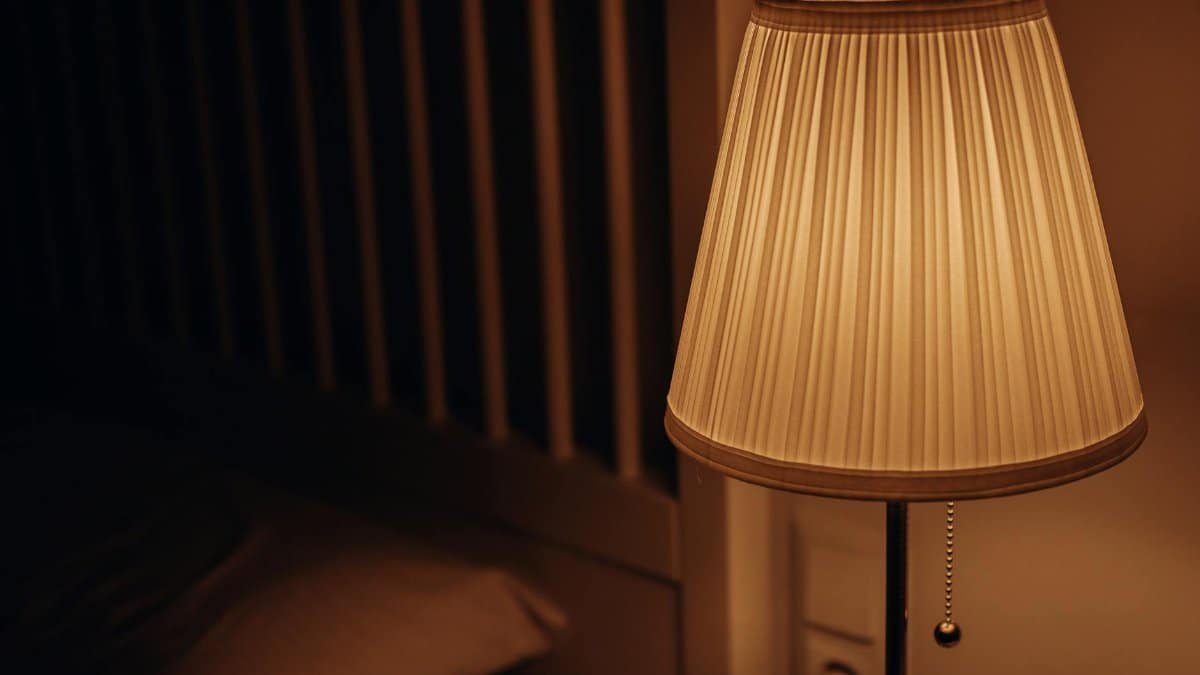 A dimly lit bedside lamp creating a warm and cozy atmosphere in a bedroom setting.
