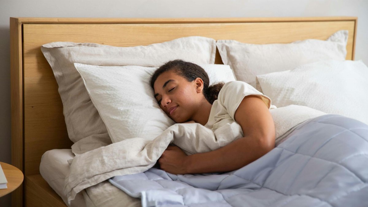 Adult resting under a cozy duvet in a serene bedroom setting promoting relaxation and wellness.