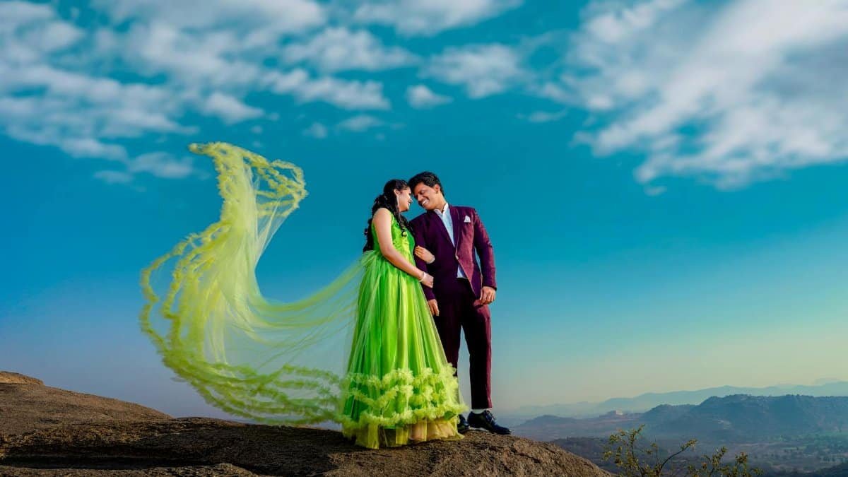 A couple posing romantically on a mountain top in India during a vibrant pre-wedding photoshoot.
