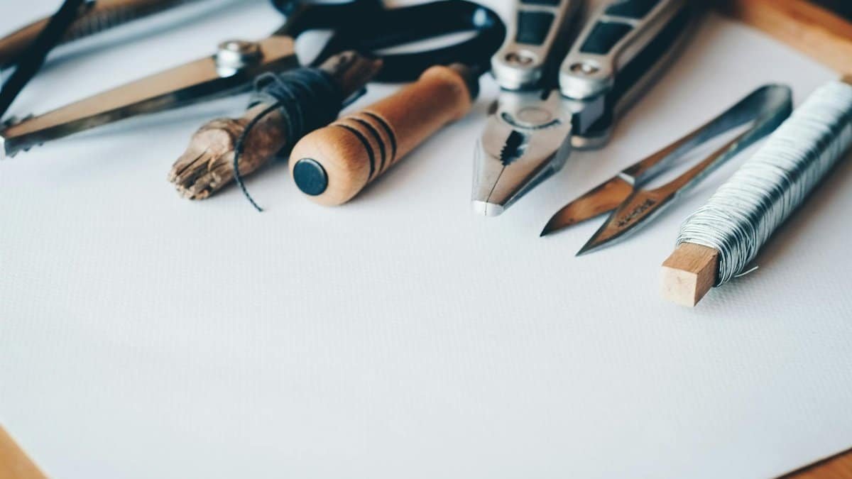A selection of artisan tools and handmade crafts displayed on a white desk, perfect for creative projects.