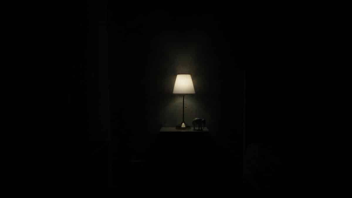 Illuminated lamp on nightstand casting a warm glow in a dark, minimalist room.