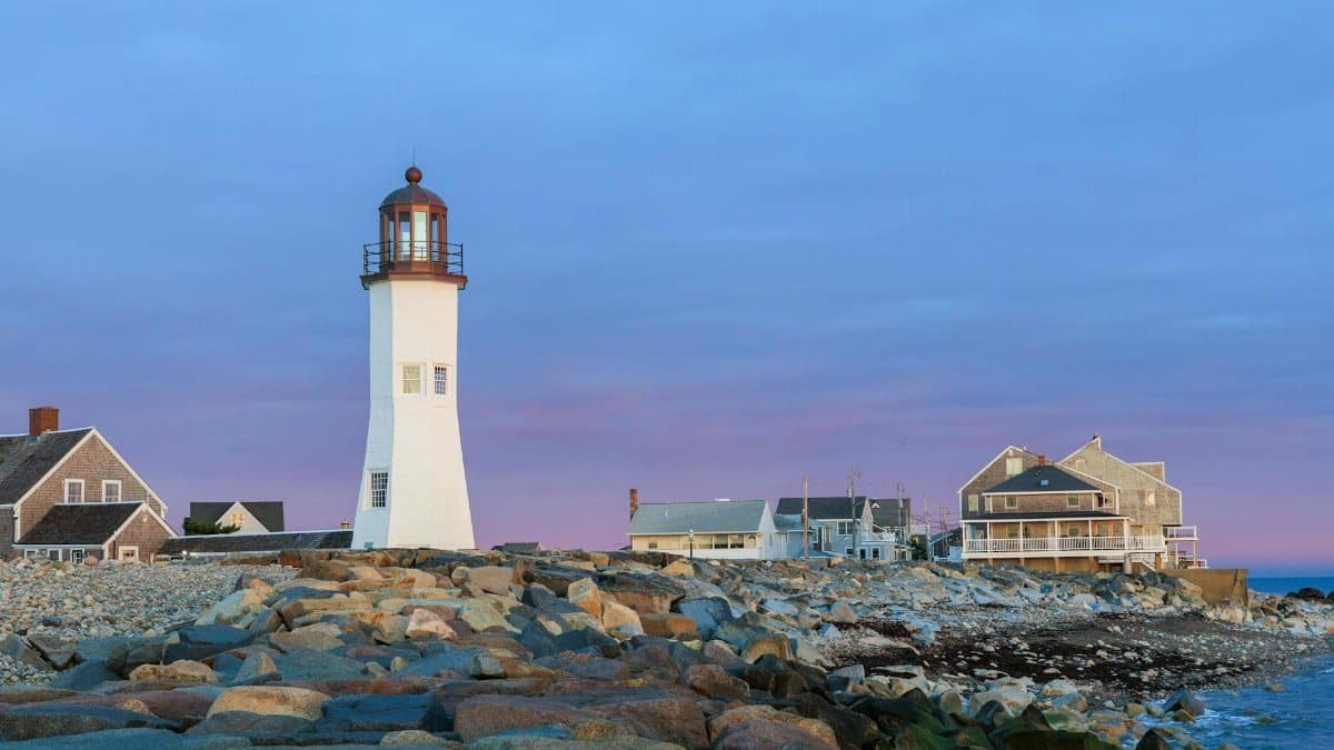 A picturesque view of Scituate Lighthouse against a sunset sky in Massachusetts.