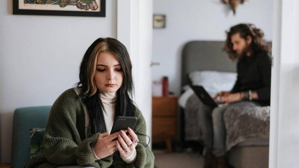 A young couple on smartphones and laptop, focusing on digital connection.