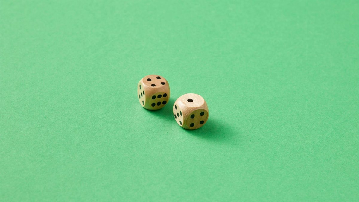 Close-up of two wooden dice on a vibrant green background.